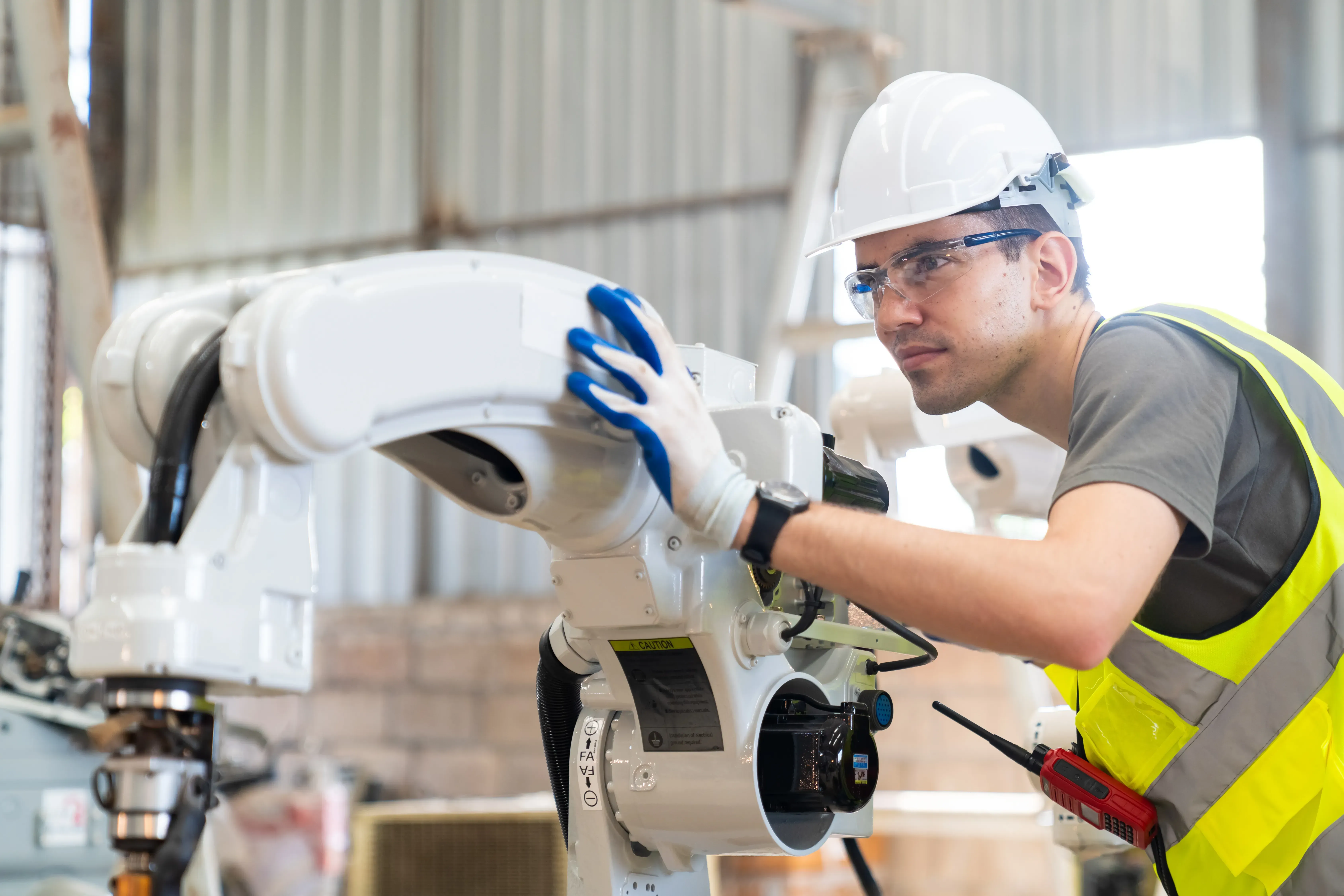 Schalterkonfektion für Maschinenbau und Industrie. Ein Techniker arbeitet an einem Industrieroboter in der Produktion