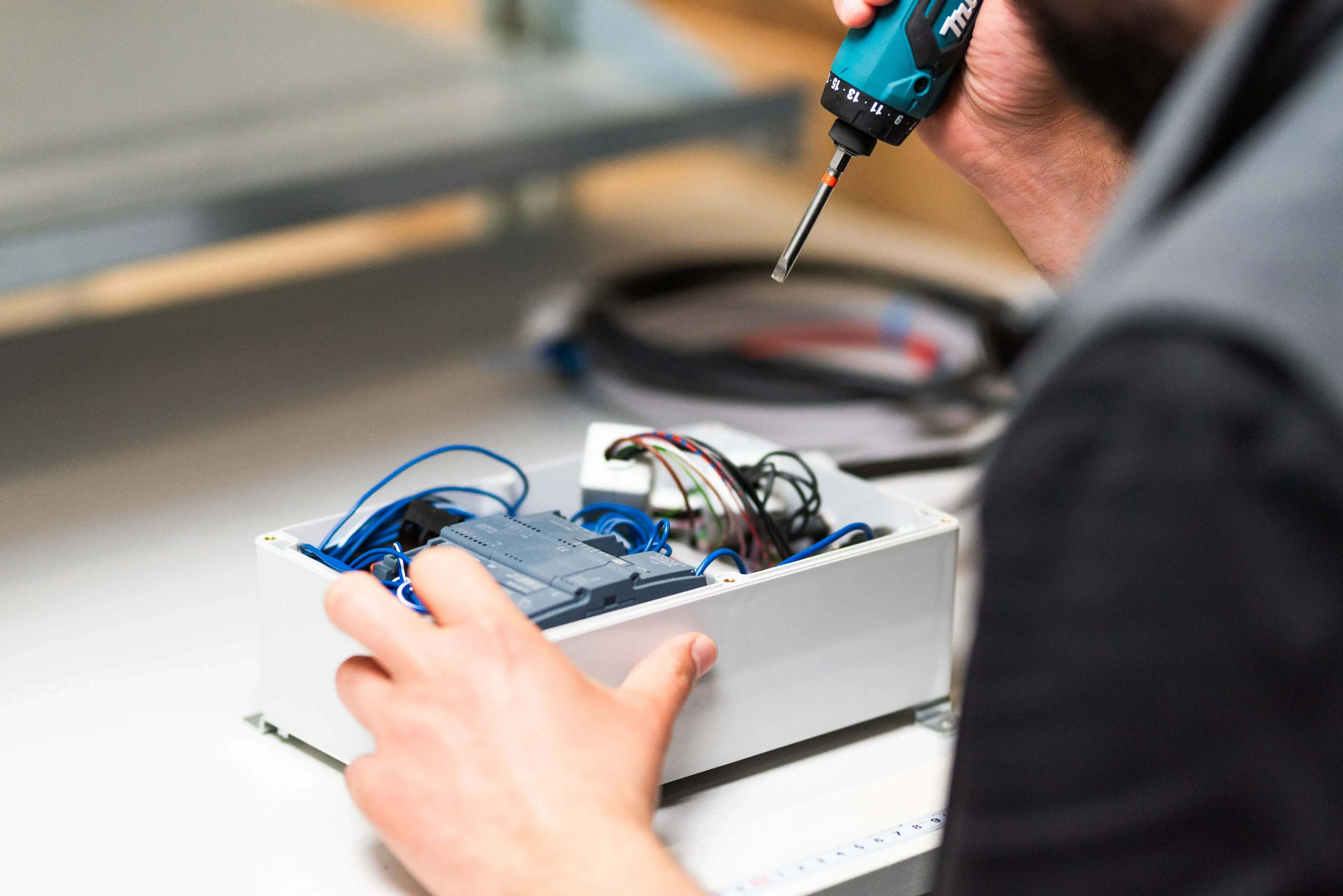 Techniker verschraubt Gehäuse eines Prototypen für die Logistik-Entwicklung – präzise Montage mit drehmomentgeregeltem Makita-Akkuschrauber